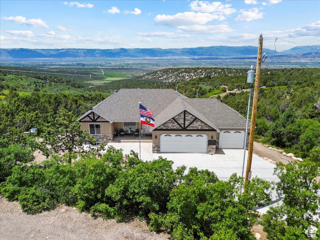 View of subject property with mountains and a heavily wooded area