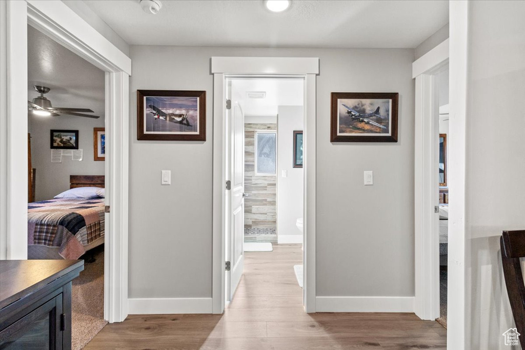 Hallway featuring light wood-type flooring and baseboards