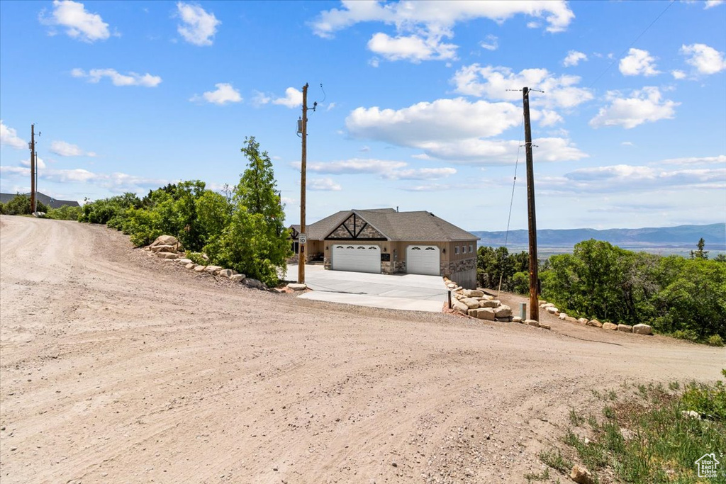 View of front of home featuring concrete driveway, an attached garage, and stone siding