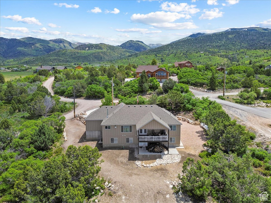 Aerial view of property and surrounding area featuring a mountain backdrop