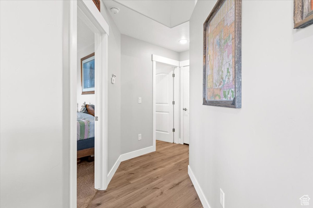 Hall with baseboards and light wood finished floors