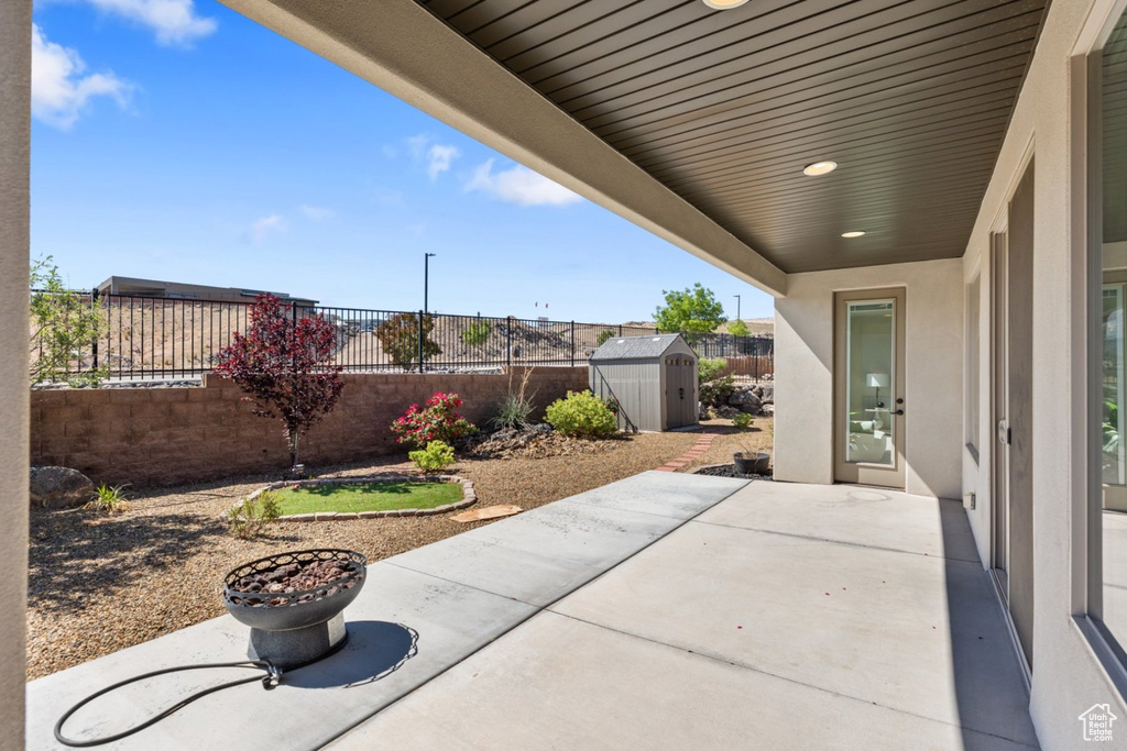View of patio / terrace featuring a storage unit, a fenced backyard, and an outdoor structure