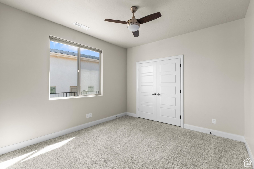 Unfurnished bedroom with carpet floors, baseboards, a closet, and ceiling fan