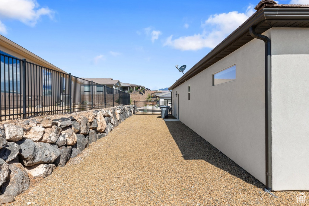 View of property exterior featuring fence, stucco siding, and a residential view