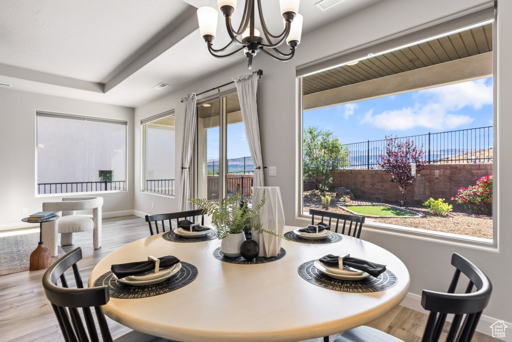 Dining area featuring a chandelier, wood finished floors, and baseboards