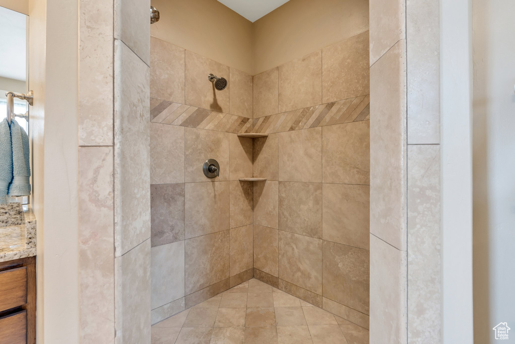 Full bath featuring vanity and a tile shower
