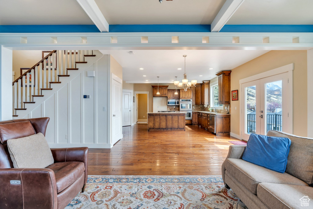 Living room with beam ceiling, french doors, a chandelier, light wood-type flooring, and recessed lighting