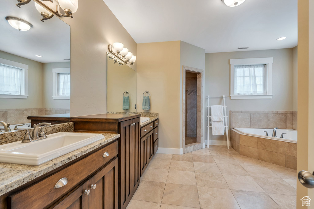Full bath featuring a bath, visible vents, tile patterned floors, tiled shower, and a sink
