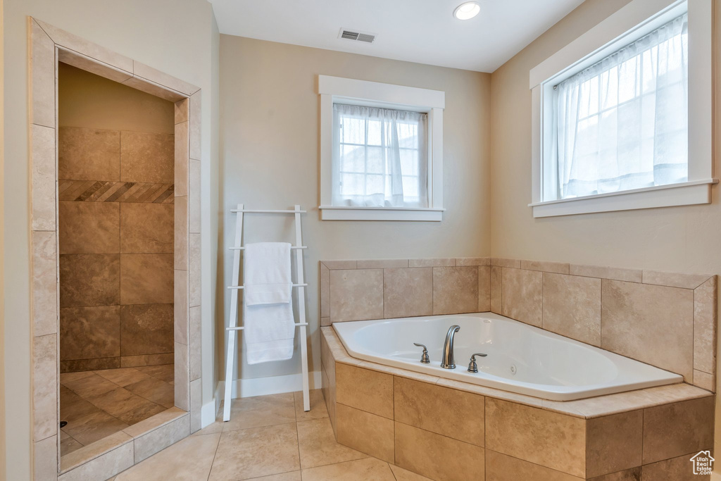Bathroom featuring a tub with jets, tile patterned floors, visible vents, and tiled shower