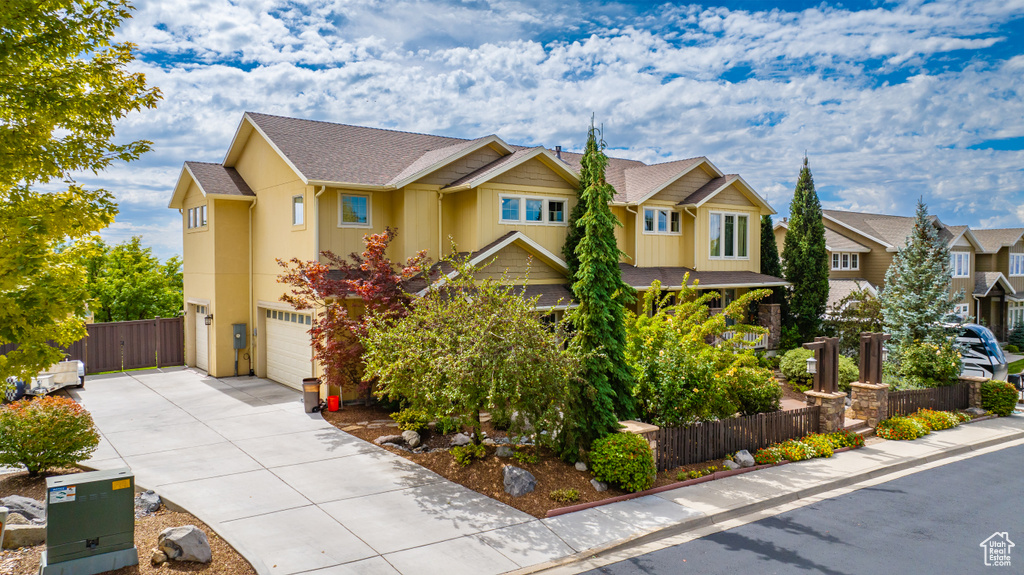 View of front of house featuring concrete driveway, stucco siding, fence, a residential view, and a garage