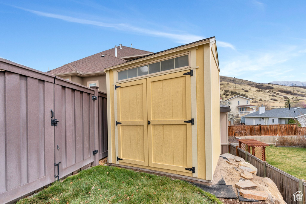 View of shed with a mountain view and fence