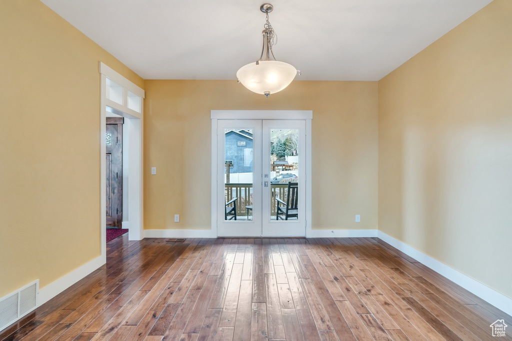 Unfurnished room with baseboards, visible vents, and wood-type flooring