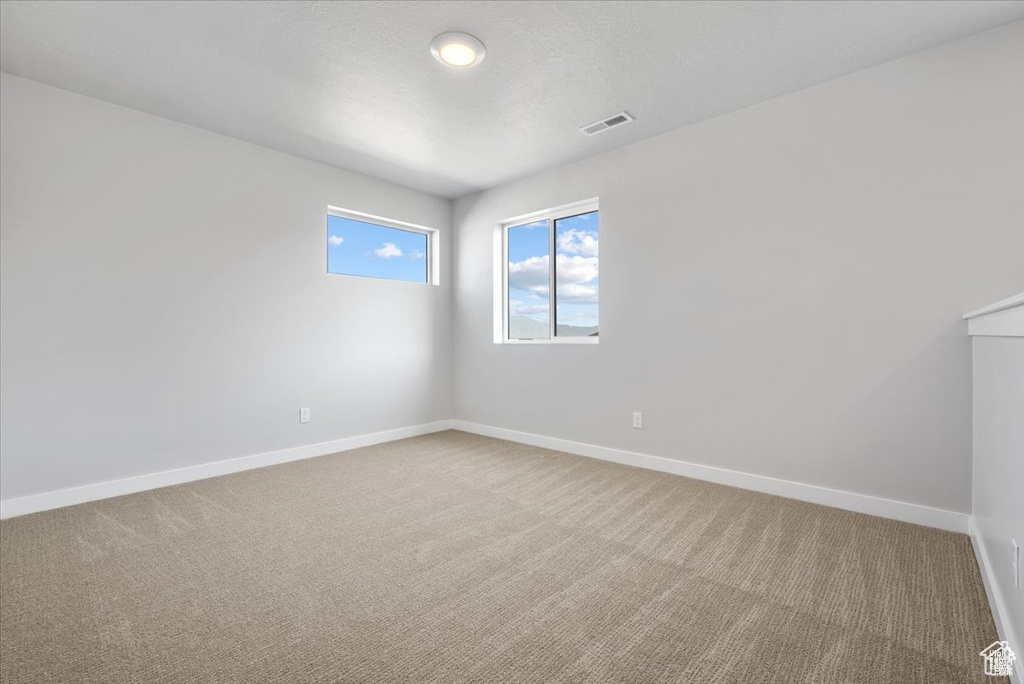 Unfurnished room with baseboards, carpet flooring, and visible vents