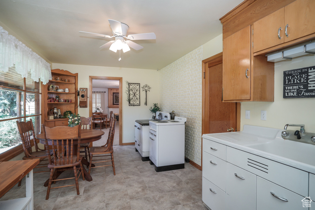 Kitchen featuring light countertops, ceiling fan, a sink, open shelves, and separate washer and dryer