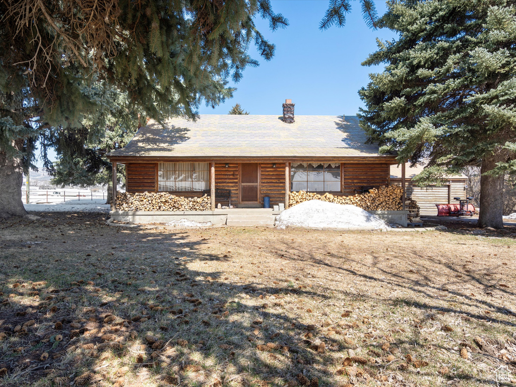 View of front of property featuring fence and a chimney