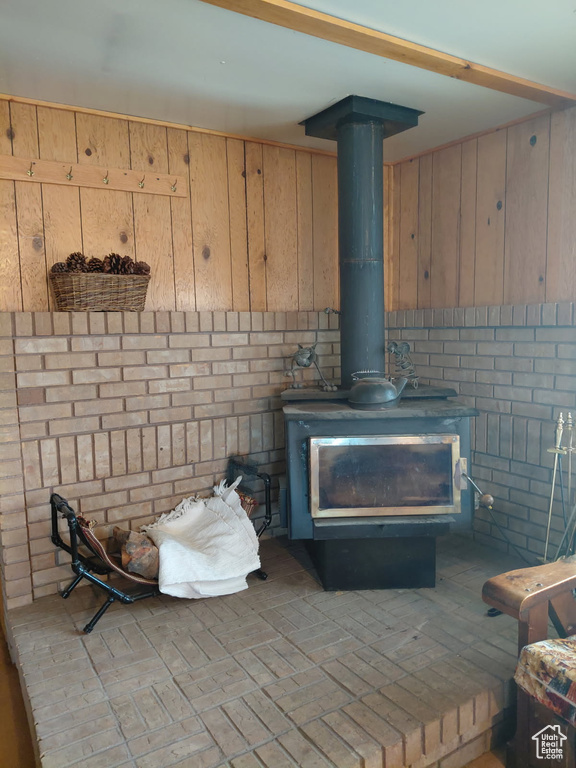 Room details featuring wooden walls and a wood stove