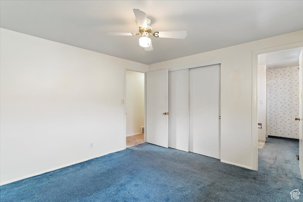Unfurnished bedroom with a ceiling fan, carpet floors, and a closet