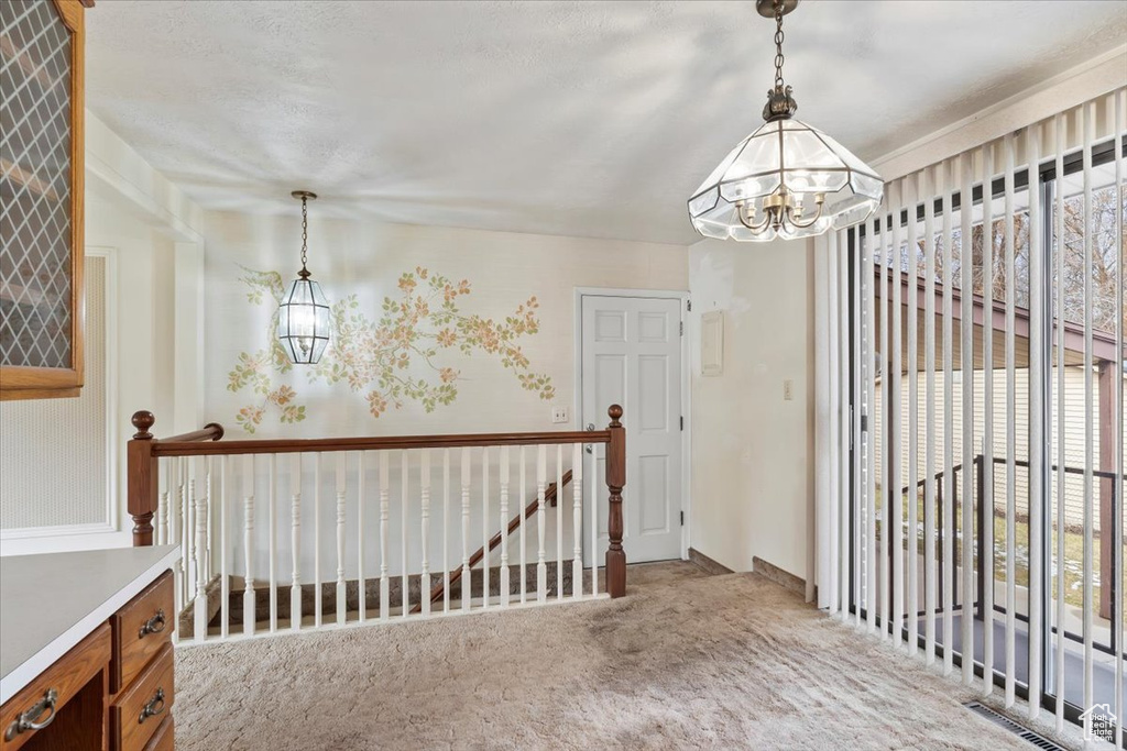 Interior space with carpet flooring, visible vents, and a chandelier