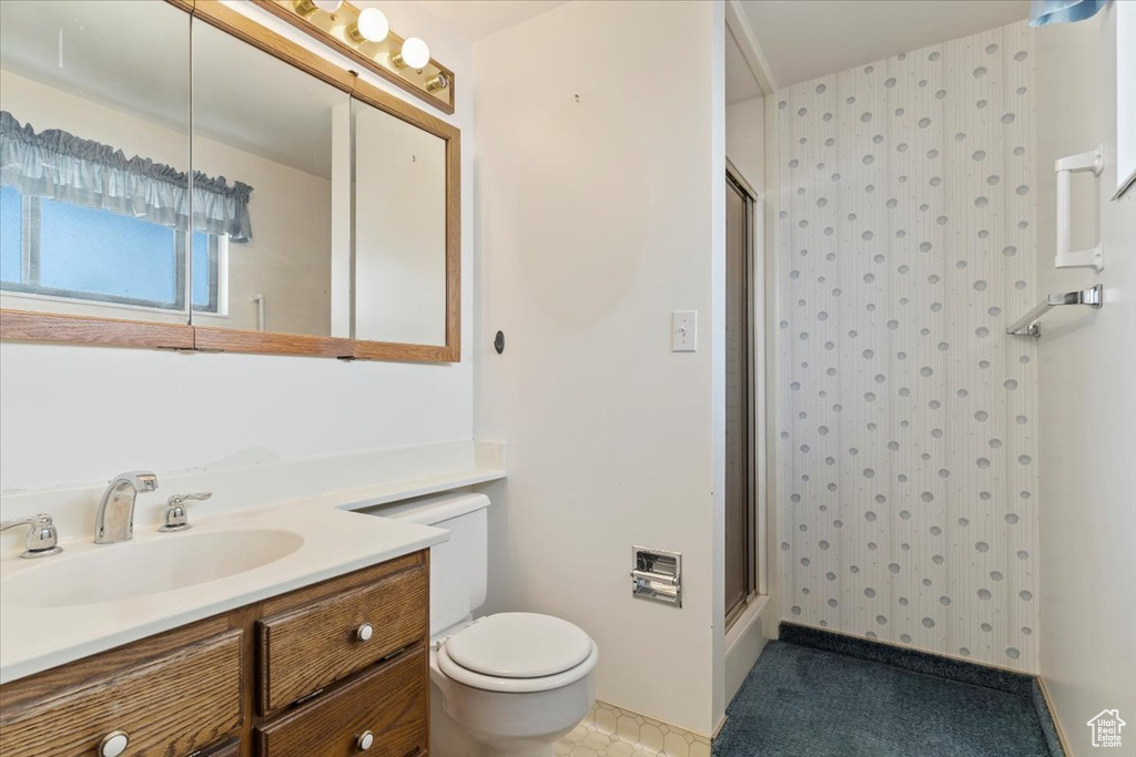 Full bath with toilet, vanity, and a shower stall