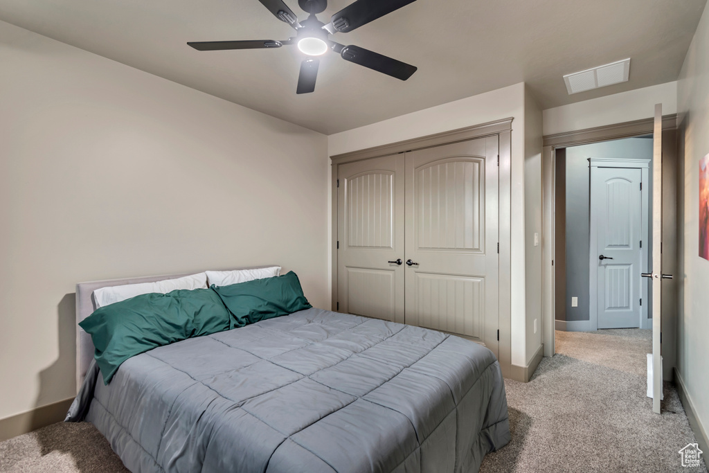 Bedroom featuring a closet, visible vents, baseboards, a ceiling fan, and carpet floors