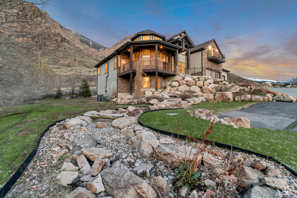 Back of house featuring a balcony and stone siding