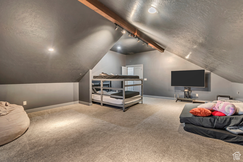 Bedroom with rail lighting, carpet floors, baseboards, and a textured ceiling