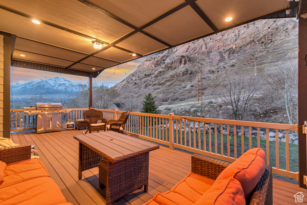 Deck with a mountain view, outdoor lounge area, and a grill