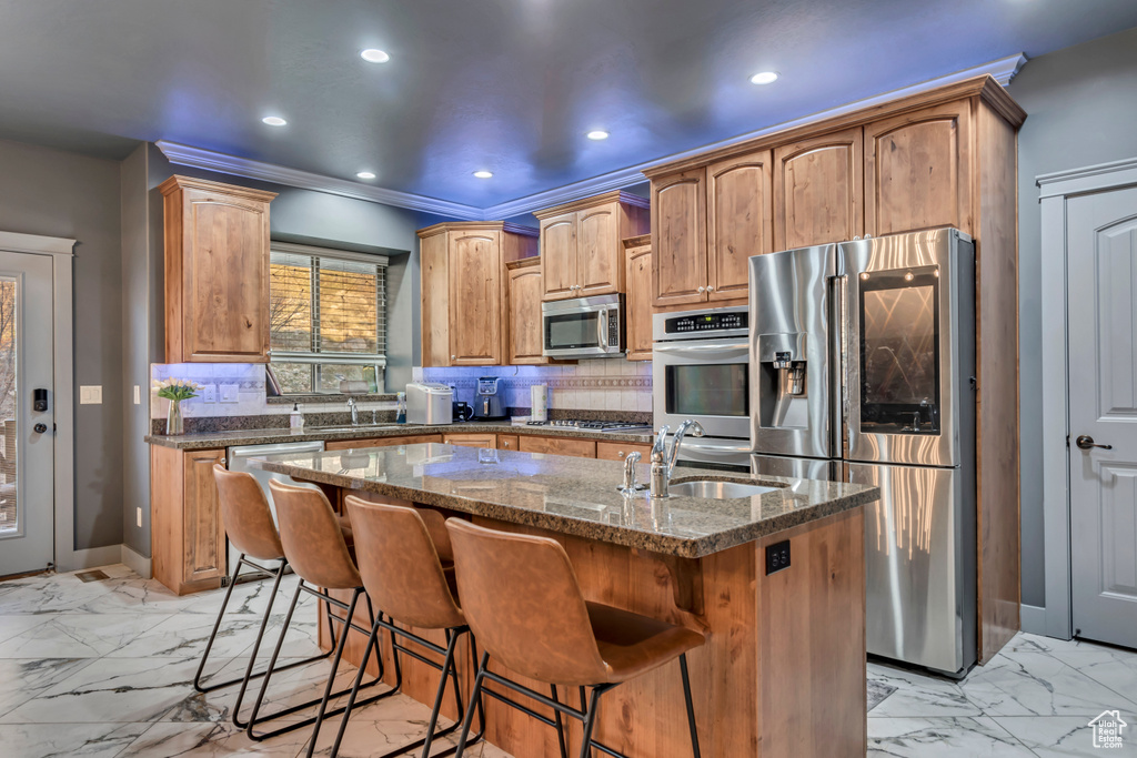 Kitchen featuring marble finish floor, a sink, stainless steel appliances, and decorative backsplash