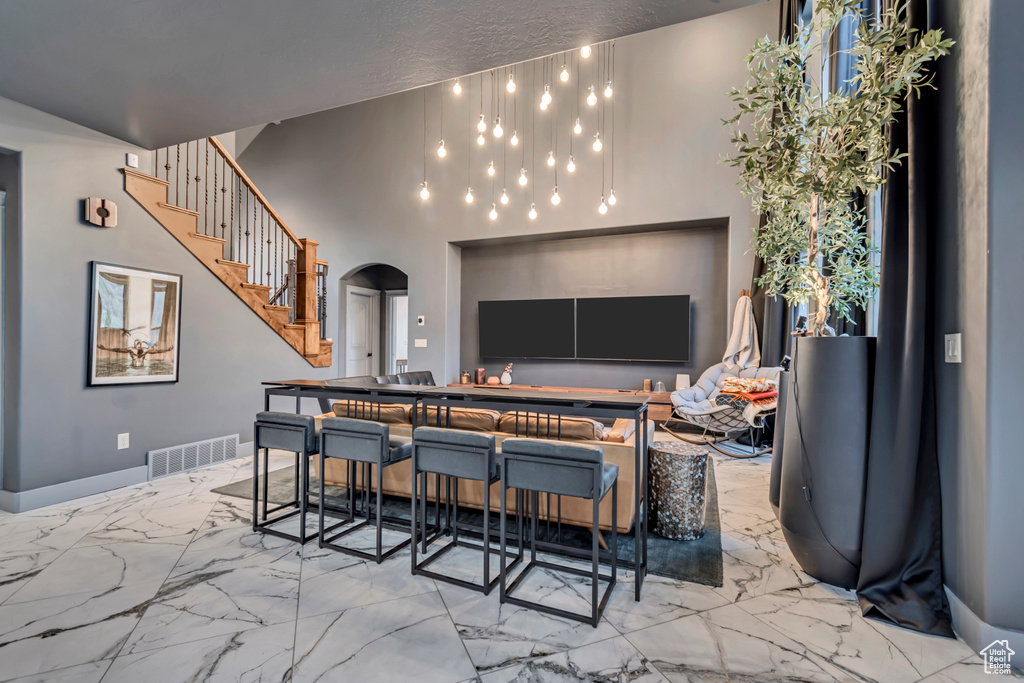 Interior space featuring marble finish floor, visible vents, arched walkways, and stairway