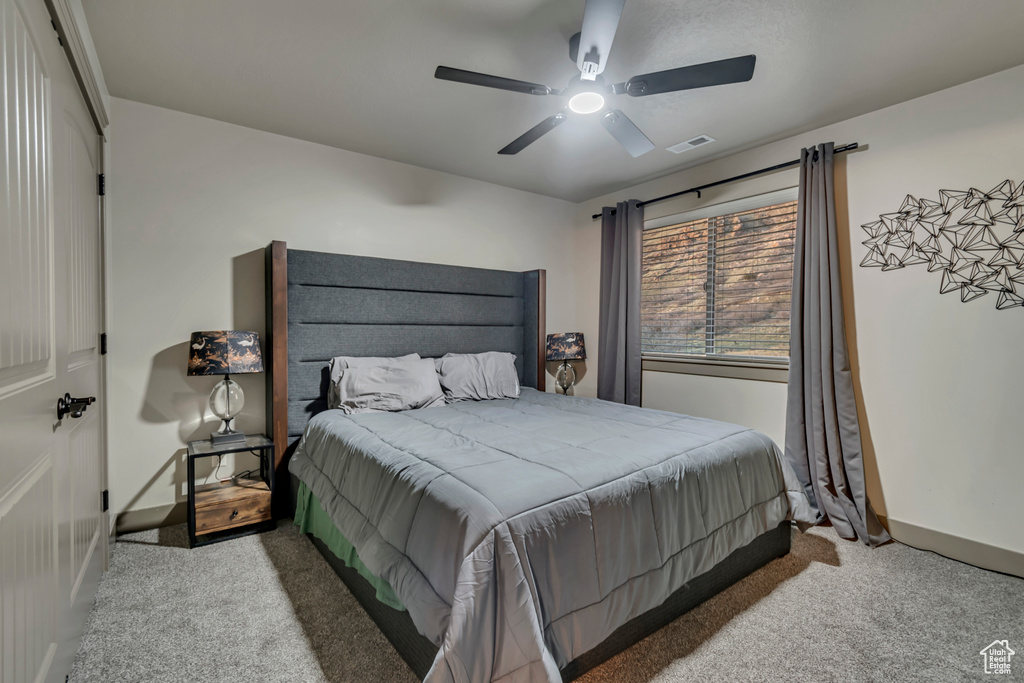 Bedroom with baseboards, carpet flooring, ceiling fan, and visible vents