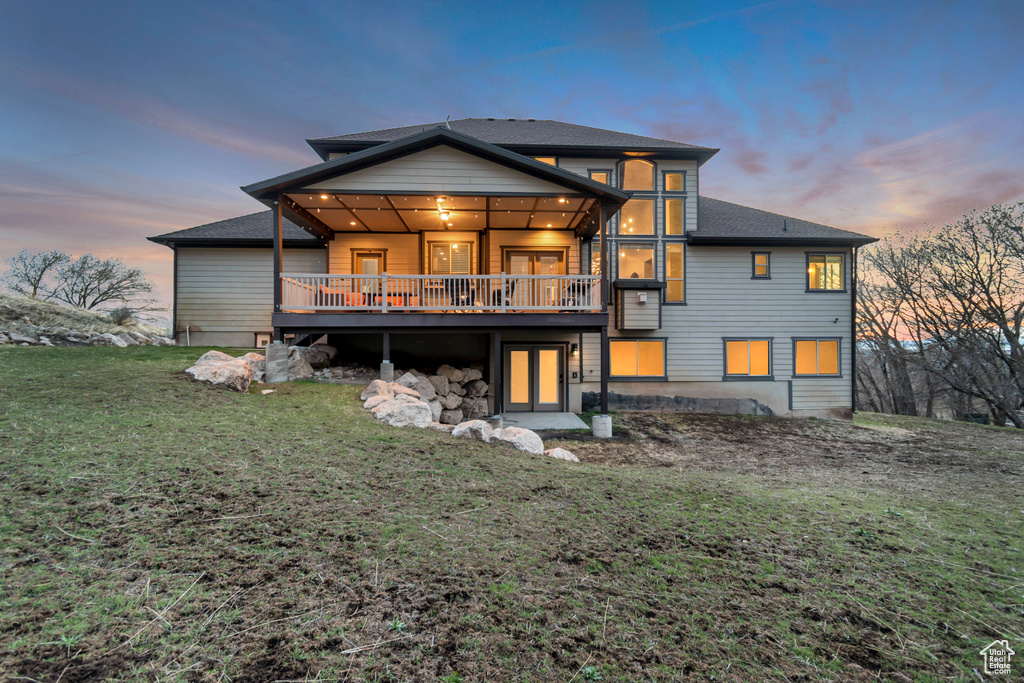 Rear view of property featuring a deck and a yard