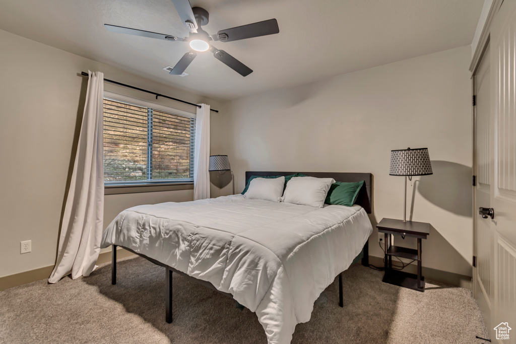 Bedroom with baseboards, carpet flooring, and a ceiling fan