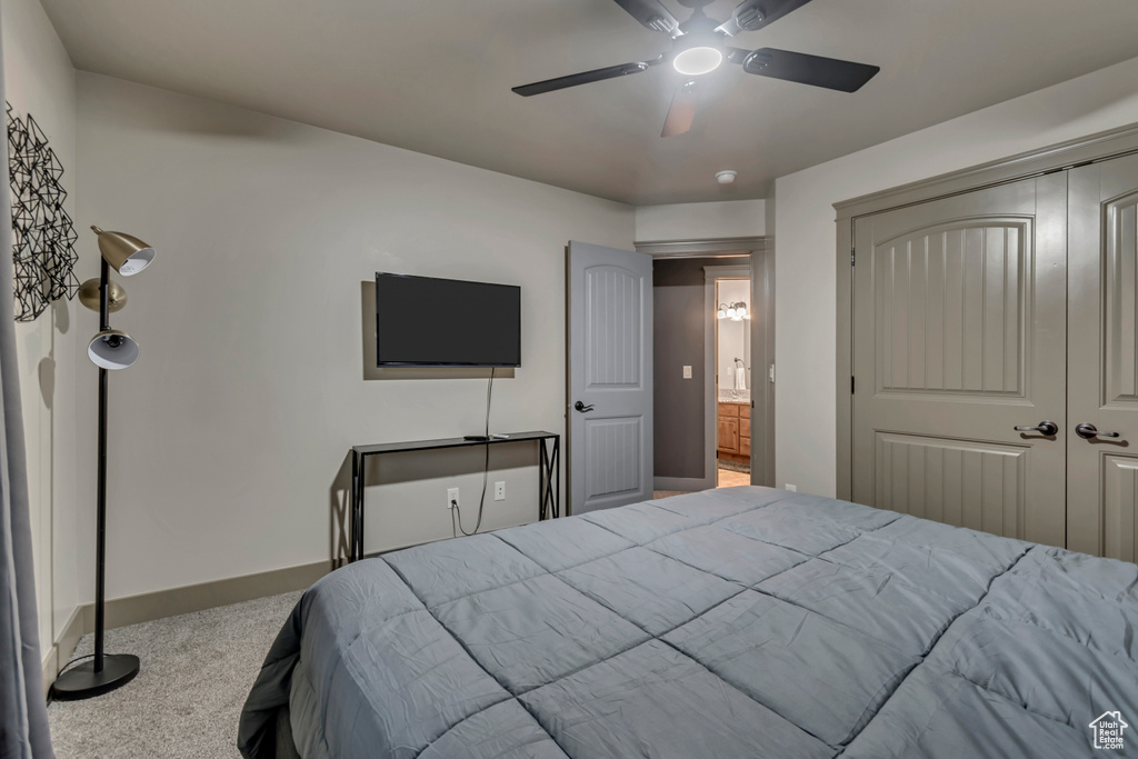 Bedroom with a closet, carpet flooring, baseboards, and a ceiling fan