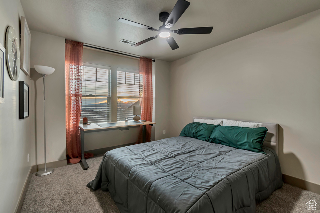 Carpeted bedroom featuring baseboards, ceiling fan, and visible vents