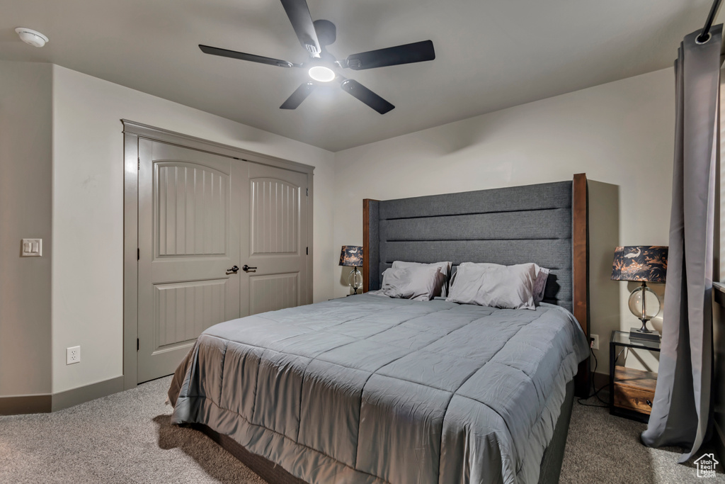 Bedroom featuring baseboards, a closet, carpet floors, and a ceiling fan