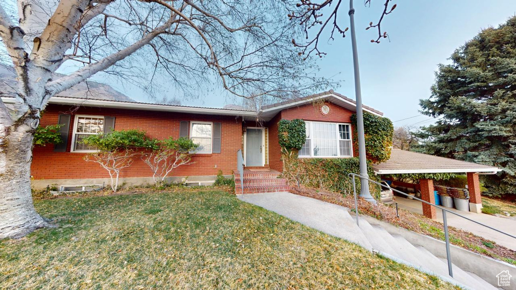 Ranch-style house with brick siding and a front lawn