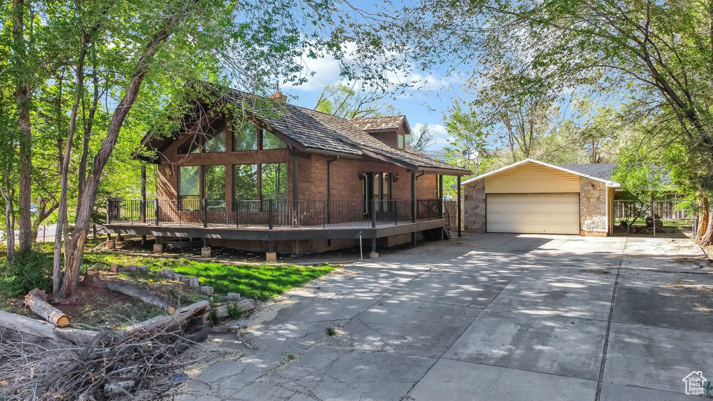 View of home\'s exterior with an outdoor structure, concrete driveway, and a deck