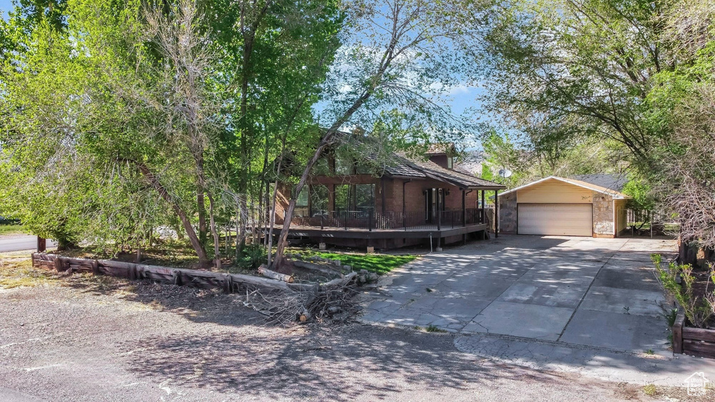 View of front of property with an outbuilding, driveway, and a chimney