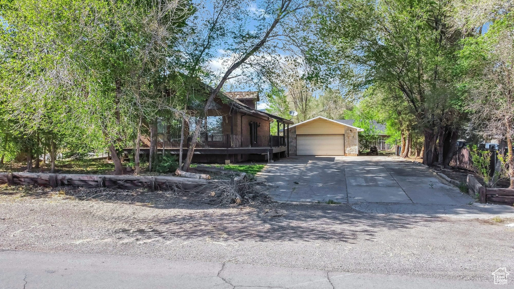 View of front of property featuring a garage, an outbuilding, and concrete driveway