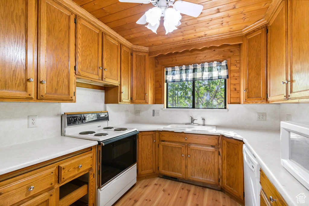 Kitchen featuring white appliances, a sink, wooden ceiling, light wood-style floors, and brown cabinetry