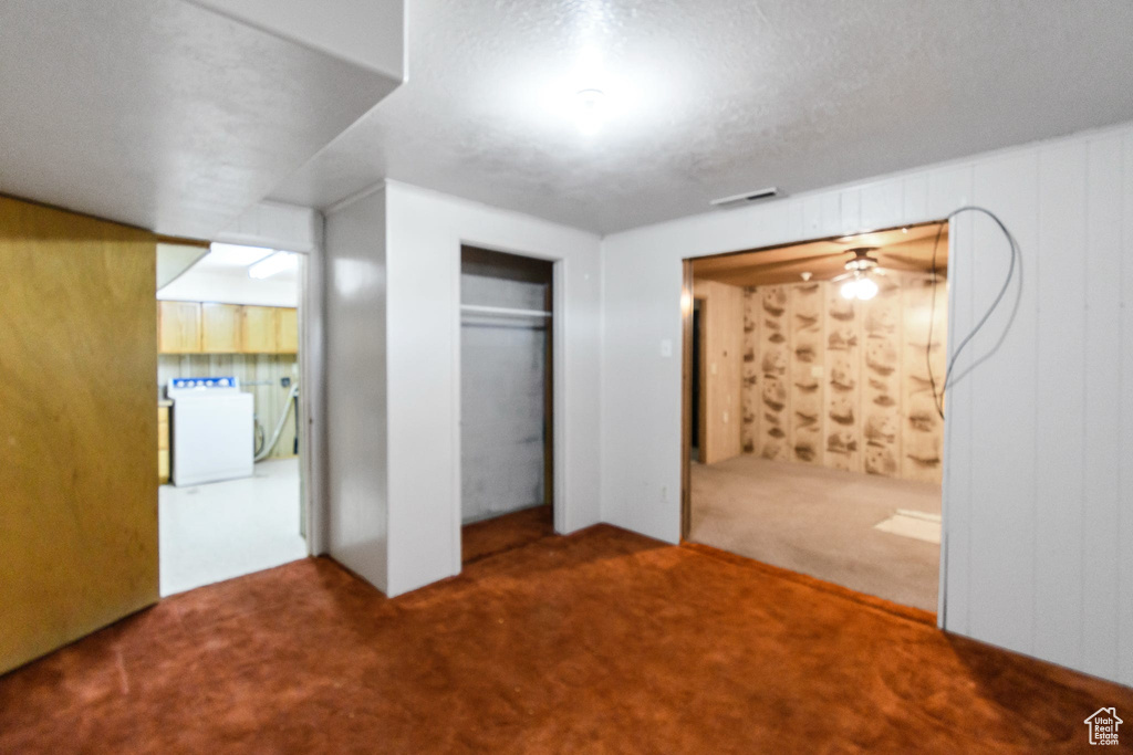 Unfurnished bedroom with washer / dryer, carpet flooring, and a closet