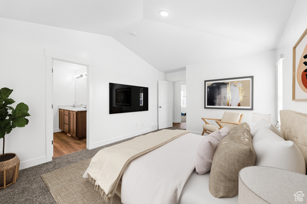 Bedroom featuring vaulted ceiling, carpet floors, and ensuite bathroom