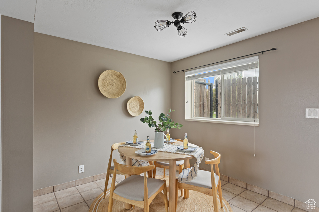 Tiled dining area with visible vents and baseboards