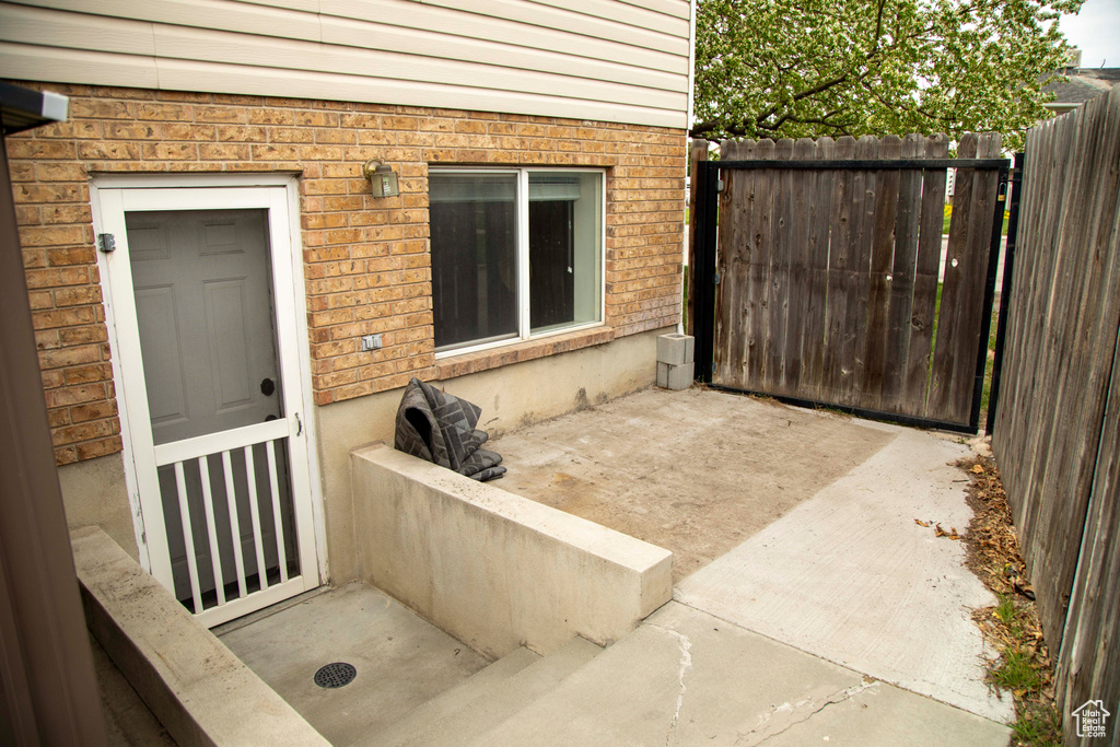 Property entrance featuring brick siding and fence