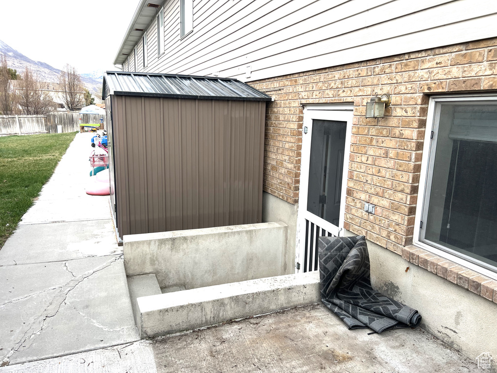 Property entrance featuring a mountain view, fence, and brick siding