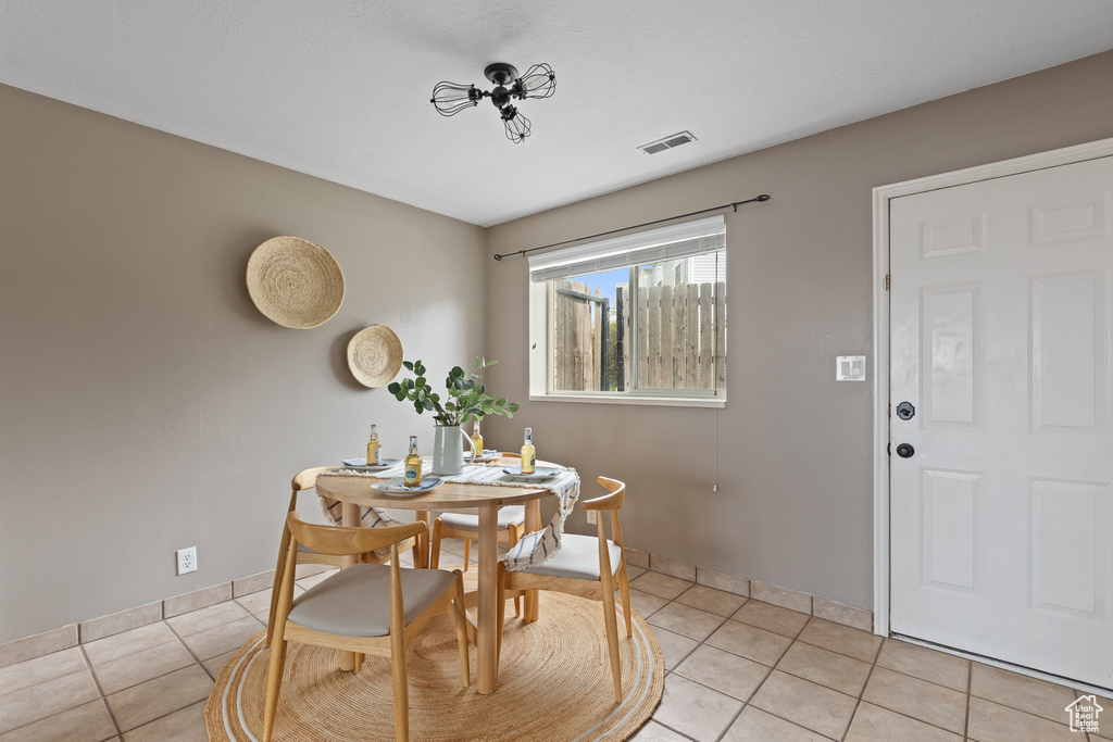 Dining room featuring light tile patterned floors, baseboards, and visible vents
