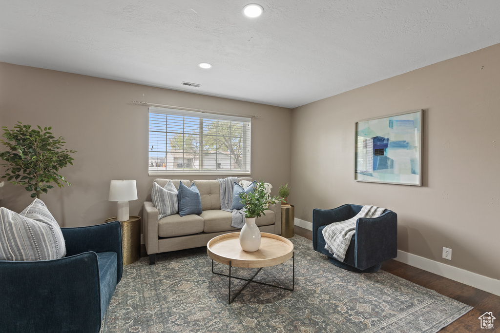 Living room with visible vents, baseboards, recessed lighting, and wood finished floors