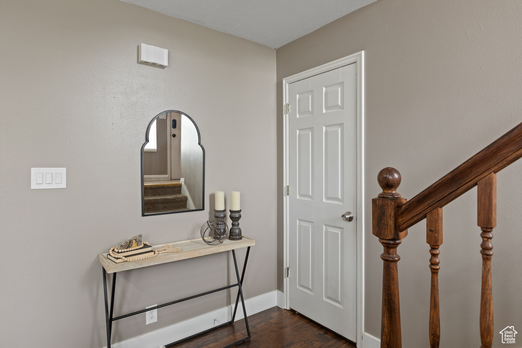 Foyer featuring stairway, baseboards, and dark wood finished floors