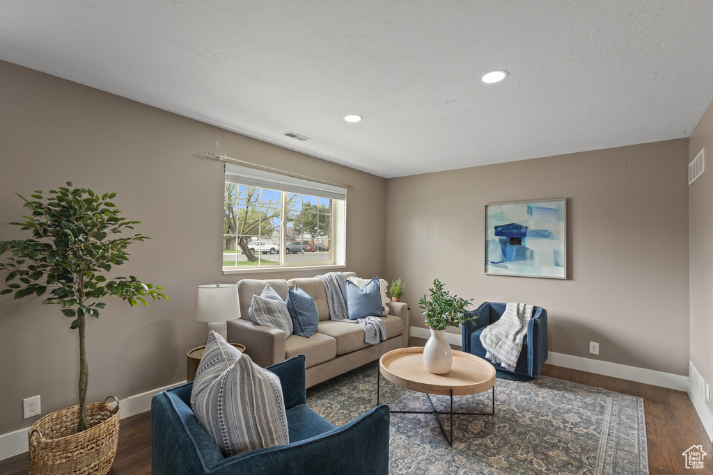 Living area with wood finished floors, baseboards, visible vents, and recessed lighting