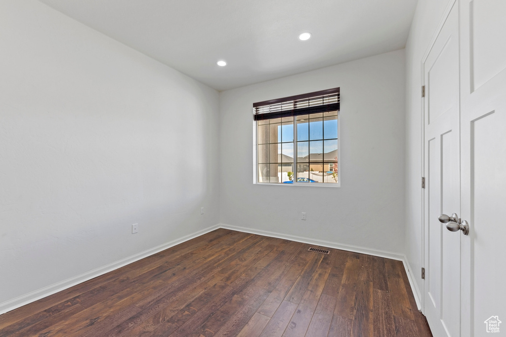 Unfurnished room featuring recessed lighting, baseboards, dark wood finished floors, and visible vents